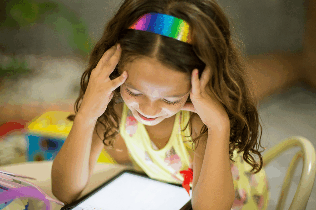 Criança sorrindo enquanto aprende com um tablet, representando o uso responsável da inteligência artificial na educação.