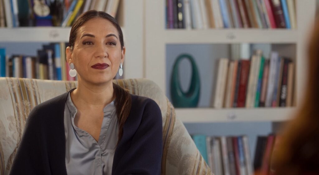 Fernanda, terapeuta interpretada por Lorena Vega, da série Invejosa da Netflix, em cena com a protagonista Vicky.