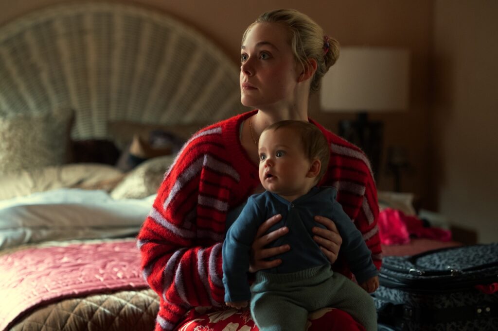 Margot segura o bebê em cena da série Margot Está em Apuros.